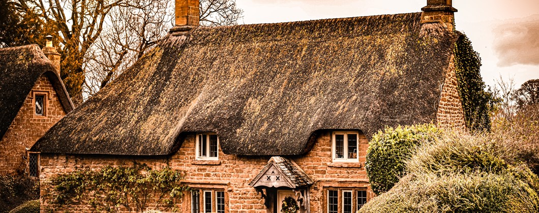 rustic thatched roof cottage with brown brickwork